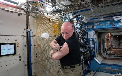 Scott Kelly gives himself a flu shot for a study on the human immune system - Credit: Nasa