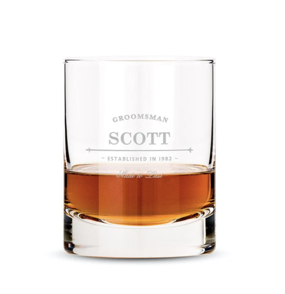 Engraved Groomsman Whiskey Glass with brown whiskey and name engraving (Photo via Etsy)