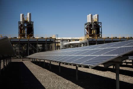 Solar panels are seen in front of a natural gas power plant at the Tahoe-Reno Industrial Center in McCarran, Nevada, September 16, 2014. REUTERS/Max Whittaker