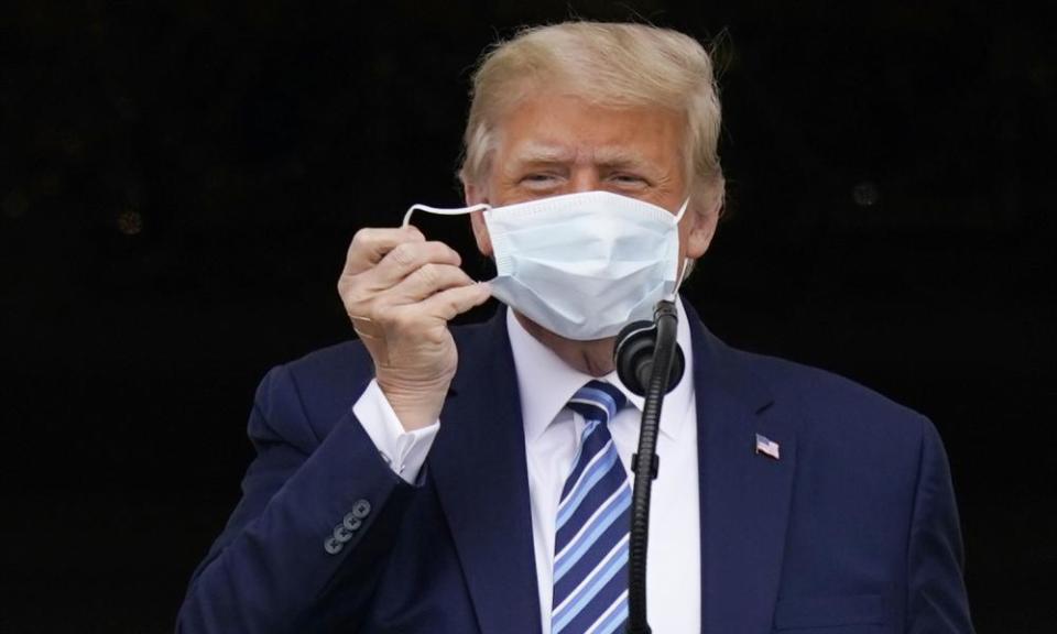 A bandage is seen on Donald Trump’s hand as he removes his face mask on 10 October.