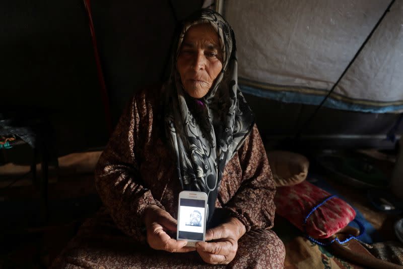 Jouriya Ali, 74, displays picture of her deceased son in Idlib