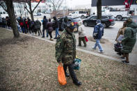 Furloughed federal worker James Grant carries food distributed by Philabundance volunteers as others affected by the partial government shutdown wait in line to receive their parcels in Philadelphia, Wednesday, Jan. 23, 2019. (AP Photo/Matt Rourke)