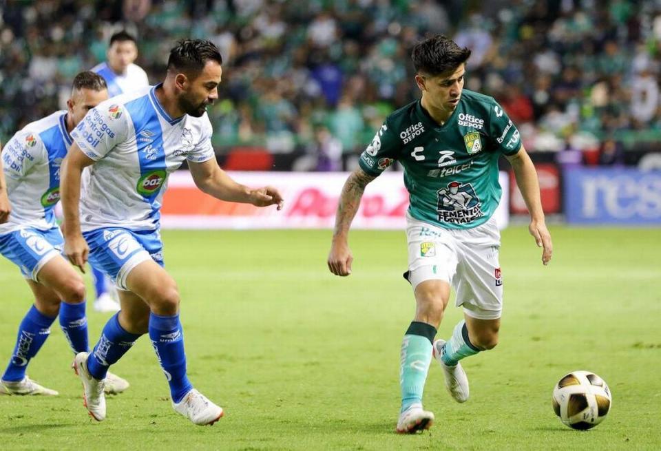 Víctor Dávila (d) de León disputa el balón con George Corral (i) de Club Puebla, durante el partido de vuelta por los cuartos de final del torneo Apertura 2021 de la Liga MX entre León y Club Puebla en el estadio León.