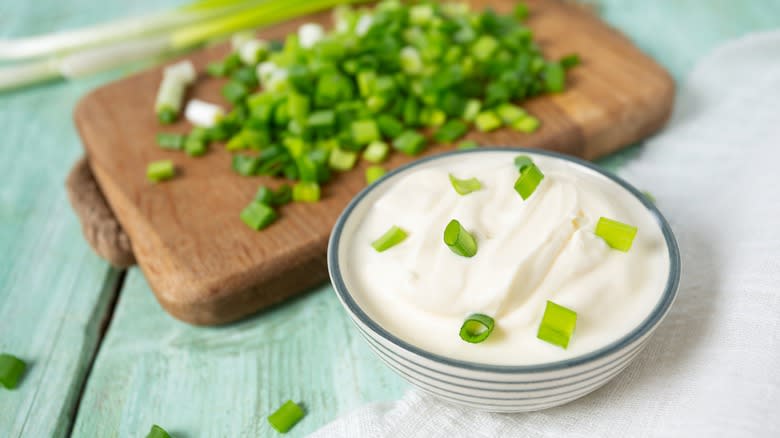 A bowl of sour cream with spring onions