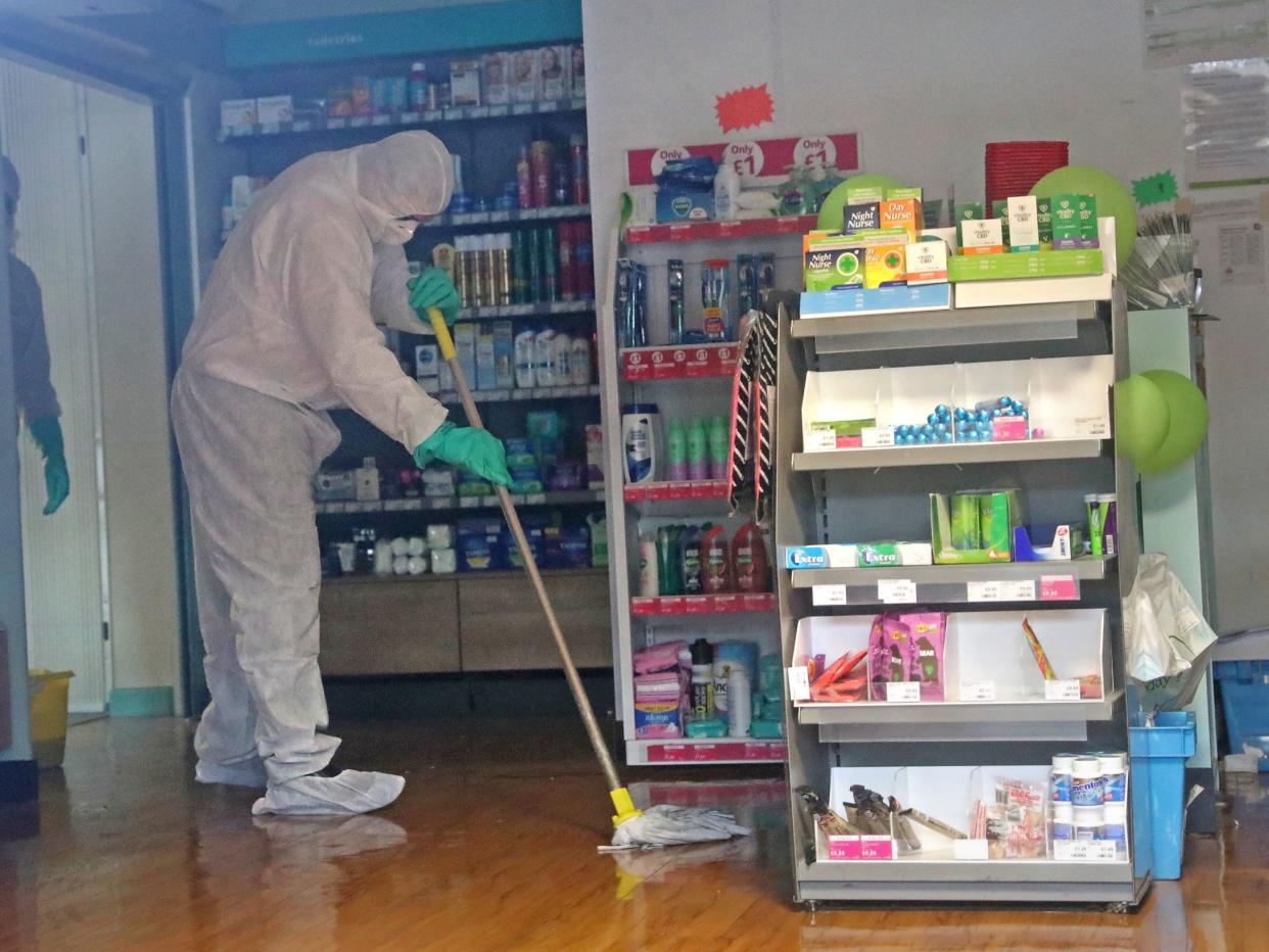 A man in protective clothing cleaning the County Oak Medical Centre GP practice in Brighton: PA