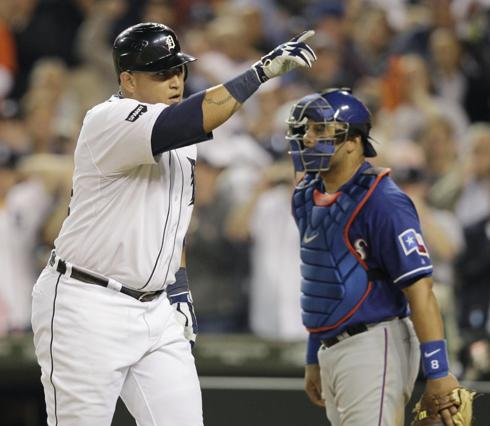 Detroit Tigers' Miguel Cabrera reacts in front of Texas Rangers' Yorvit Torrealba after hitting a solo home run during the seventh inning of Game 3 of baseball's American League championship series Tuesday, Oct. 11, 2011, in Detroit. (AP Photo/Paul Sancya)