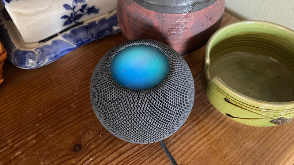 HomePod Mini with its top panel glowing blue when Siri is activated