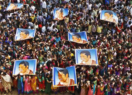 School children wave as they hold posters of Indian cricketer Sachin Tendulkar at an event to honour him inside a school in the southern Indian city of Chennai November 14, 2013. Cricket-crazy India will have a lump in the throat as its favourite son, Tendulkar, walks out for one last time this week to play the game he has dominated for nearly a quarter of a century. The 'Little Master' will bring the curtain down on a glittering 24-year career at the age of 40 when he plays his 200th test match, against West Indies, at his home ground starting on Thursday. REUTERS/Babu
