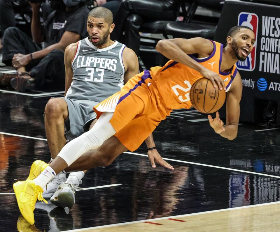 Clippers forward Nicolas Batum draws a charging foul against Suns forward Mikal Bridges.