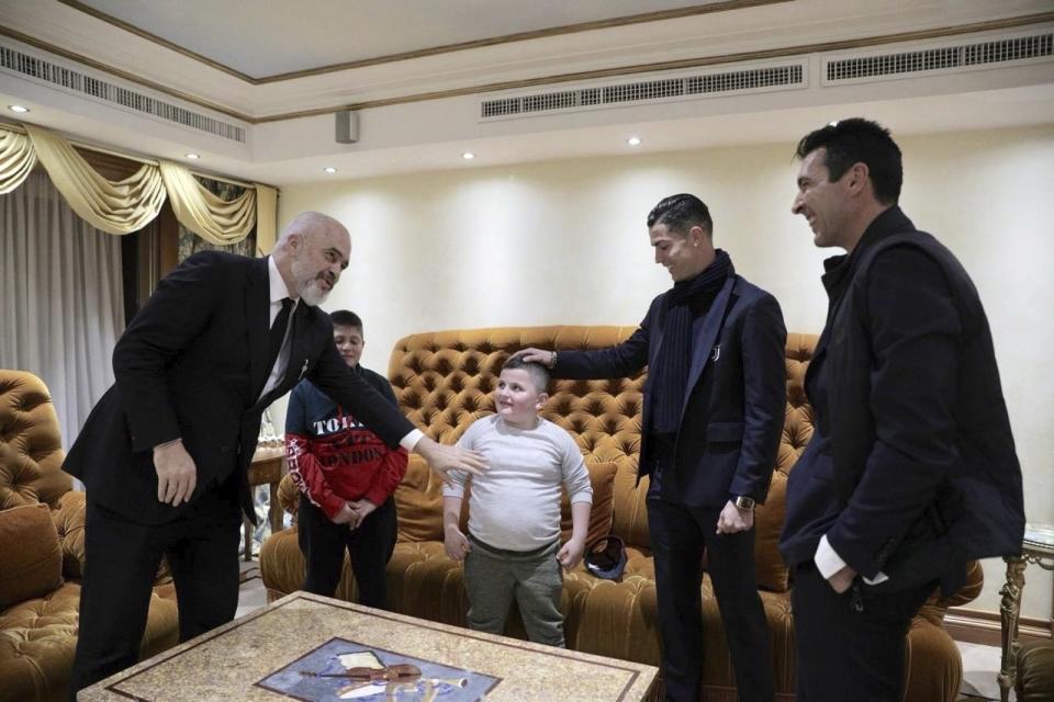 Albanian Prime Minister Edi Rama, left, Juventus' players Cristiano Ronaldo, second right, and Gianluigi Buffon, right, meet with Aurel Lala and Alesio Cakoni, in Rome on Friday, Dec. 6, 2019. The two Albanian children were injured when they escaped their collapsing flat jolted from the Nov. 26 6.4-magnitude earthquake, that killed 51 persons and injured more than 3,000 others. They lost each two family members but their dream came true when Rama took them to Rome, Italy to meet with their sport idols Ronaldo and Buffon. (Albanian Prime Minister Office via AP)