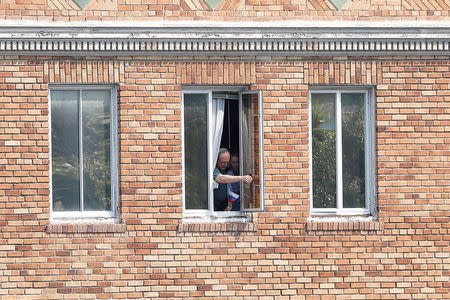 Two unidentified people place a Russian flag from a window at the Consulate General of Russia in San Francisco, California, U.S., September 2, 2017. REUTERS/Stephen Lam
