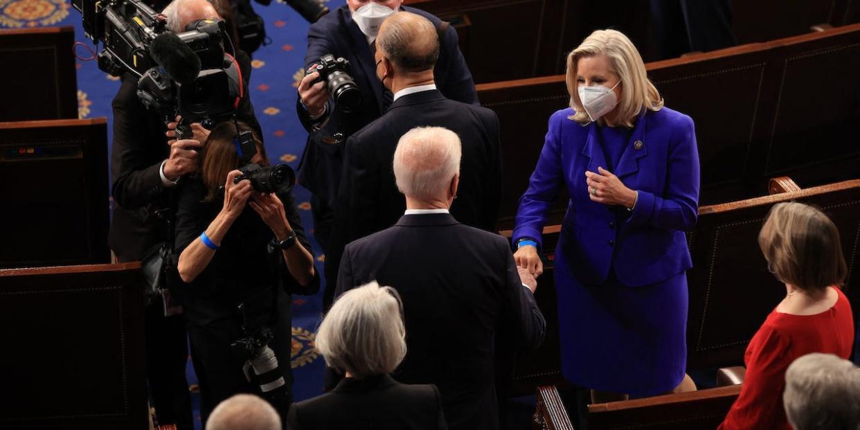 President Joe Biden (C) greets Rep. Liz Cheney (R-WY) with a fist bump before addressing a joint session of congress in the House chamber of the US Capitol April 28, 2021 in Washington, DC.