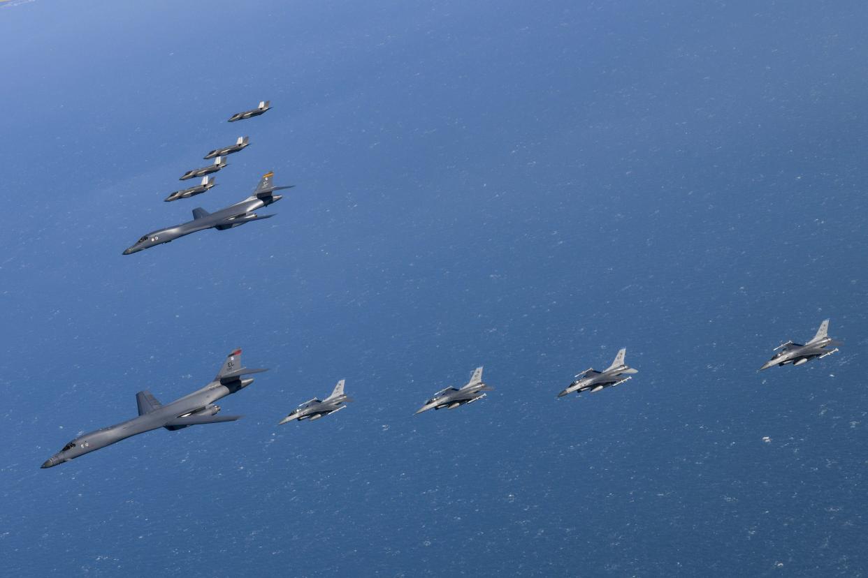 In this photo provided by South Korea Defense Ministry, U.S. Air Force B-1B bombers, center, fly in formation with South Korea's Air Force F-35A fighter jets, top, and U.S. Air Force F-16 fighter jets, bottom, over the South Korea Peninsula during a joint air drill in South Korea, Sunday, Feb. 19, 2023. (South Korea Defense Ministry via AP)