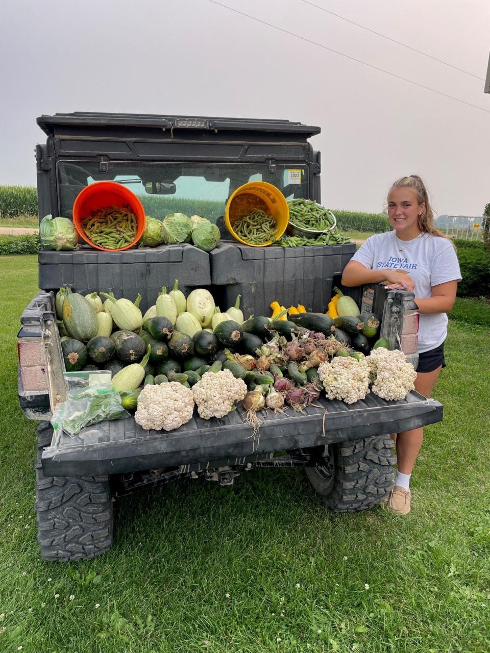 Lauren Schroeder poses with a haul of produce she grew.