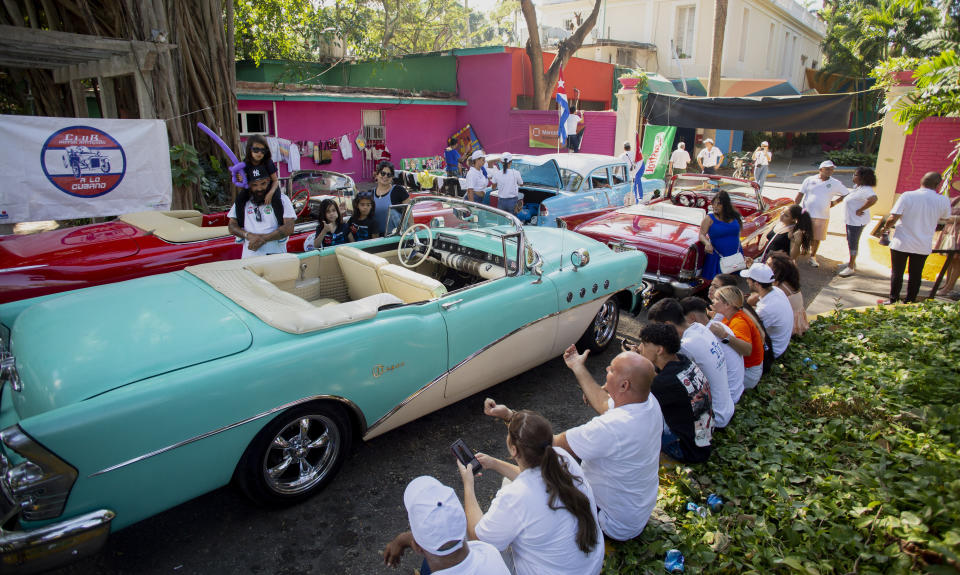 Propietarios y conductores de automóviles y motocicletas clásicos y antiguos se reúnen antes del inicio del Rally de Autos Antiguos de La Habana, en La Habana, Cuba, el domingo 3 de diciembre de 2023. El rally celebra el 125to aniversario de la llegada del primer automóvil a la isla. (Foto AP/Ismael Francisco)