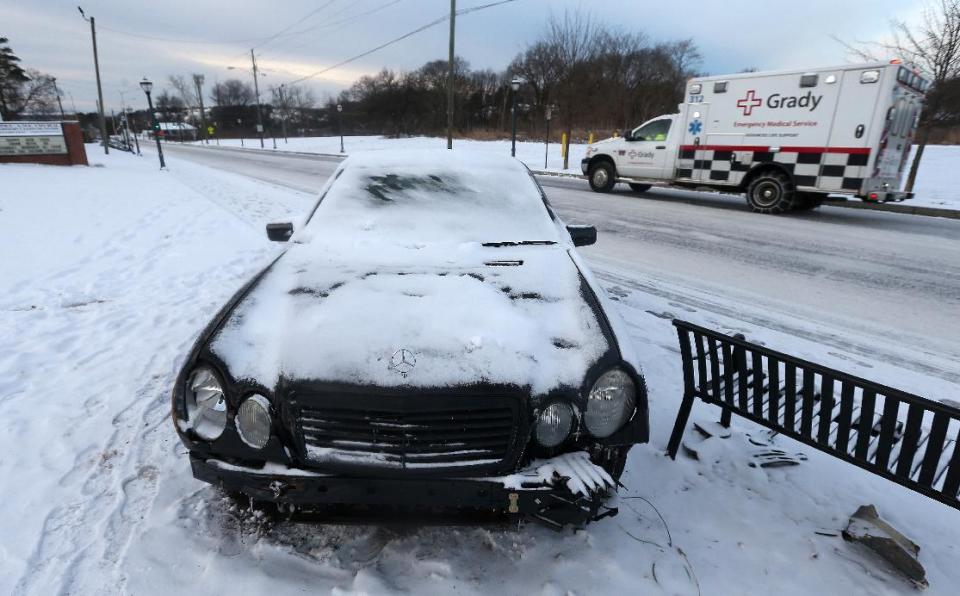 A damaged car is left on the side of the road, stuck in snow off Pryor Road, Wednesday, Jan. 29, 2014 in Atlanta. After a rare snowstorm stopped Atlanta-area commuters in their tracks, forcing many to hunker down in their cars overnight or seek other shelter, the National Guard was sending military Humvees onto the city's snarled freeway system in an attempt to move stranded school buses and get food and water to students on them, Gov. Nathan Deal said early Wednesday. (AP Photo/Atlanta Journal-Constitution, Ben Gray) MARIETTA DAILY OUT; GWINNETT DAILY POST OUT; LOCAL TV OUT; WXIA-TV OUT; WGCL-TV OUT