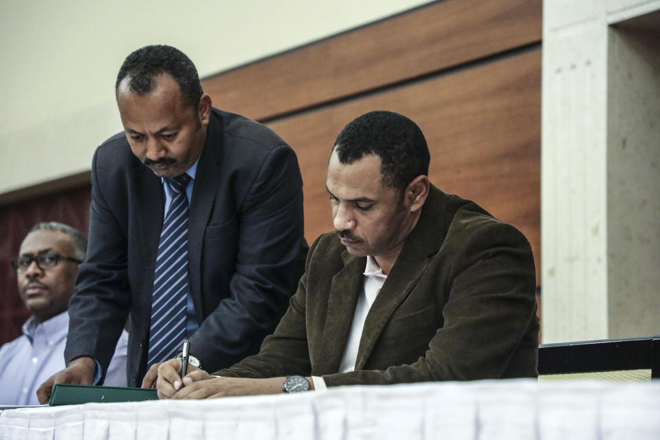 Sudan's pro-democracy movement leader Ahmad al-Rabiah signs a power sharing document with the ruling military council in Khartoum, Sudan, Wednesday, July 17, 2019. The two sides are still at work on a more contentious constitutional agreement that would specify the division of powers. (AP Photo/Mahmoud Hjaj)