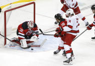 New Jersey Devils goaltender Jon Gillies (32) makes a save against Carolina Hurricanes defenseman Jaccob Slavin (74) during the third period of an NHL hockey game, Saturday, Jan. 22, 2022, in Newark, N.J. (AP Photo/Noah K. Murray)