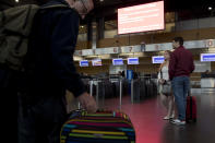 Passengers stand in front of Ryanair airline check-in desks during a Ryanair employees strike at the Charleroi airport, outside Brussels, Friday, Sept. 28, 2018. Ryanair pilots and cabin crew went on strike forcing the cancellation of some 250 flights across Europe, including Spain, Portugal, Belgium, the Netherlands, Italy and Germany. (AP Photo/Francisco Seco)