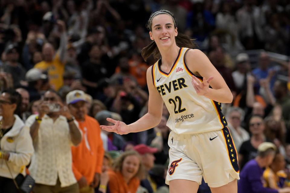 Indiana Fever guard Caitlin Clark (22) smiles as she heads down court after a 3-point basket in the final seconds of the game against the Los Angeles Sparks at Crypto.com Arena.