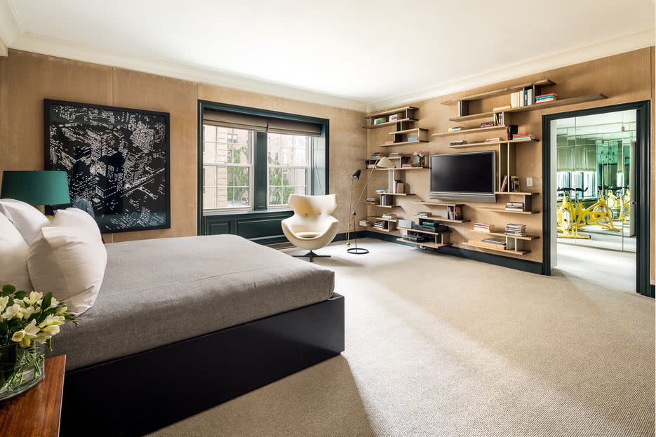 Another view of the master bedroom shows an exercise bike in an adjoining room.