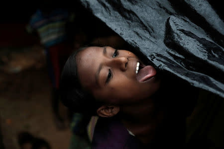 A Rohingya refugee girl drinks rain water in a camp in Cox's Bazar, Bangladesh, September 20, 2017. REUTERS/Cathal McNaughton