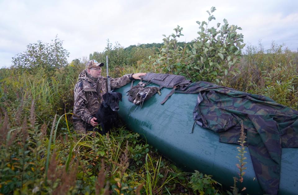 Jim Henning of Grafton and his Labrador retriever Tess sit next to their stashed canoe on a duck hunt Sept. 25 at Crex Meadows Wildlife Area near Grantsburg.