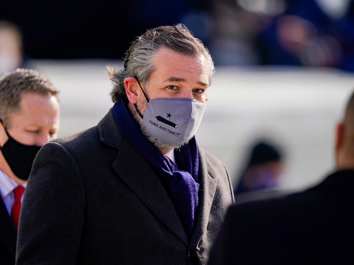 <p>Ted Cruz (C) (R-TX), wearing a face mask that reads “Come and Take It”, arrives to the inauguration of Joe Biden on the West Front of the US Capitol on 20 January 2021 in Washington, DC</p> ((Getty Images))