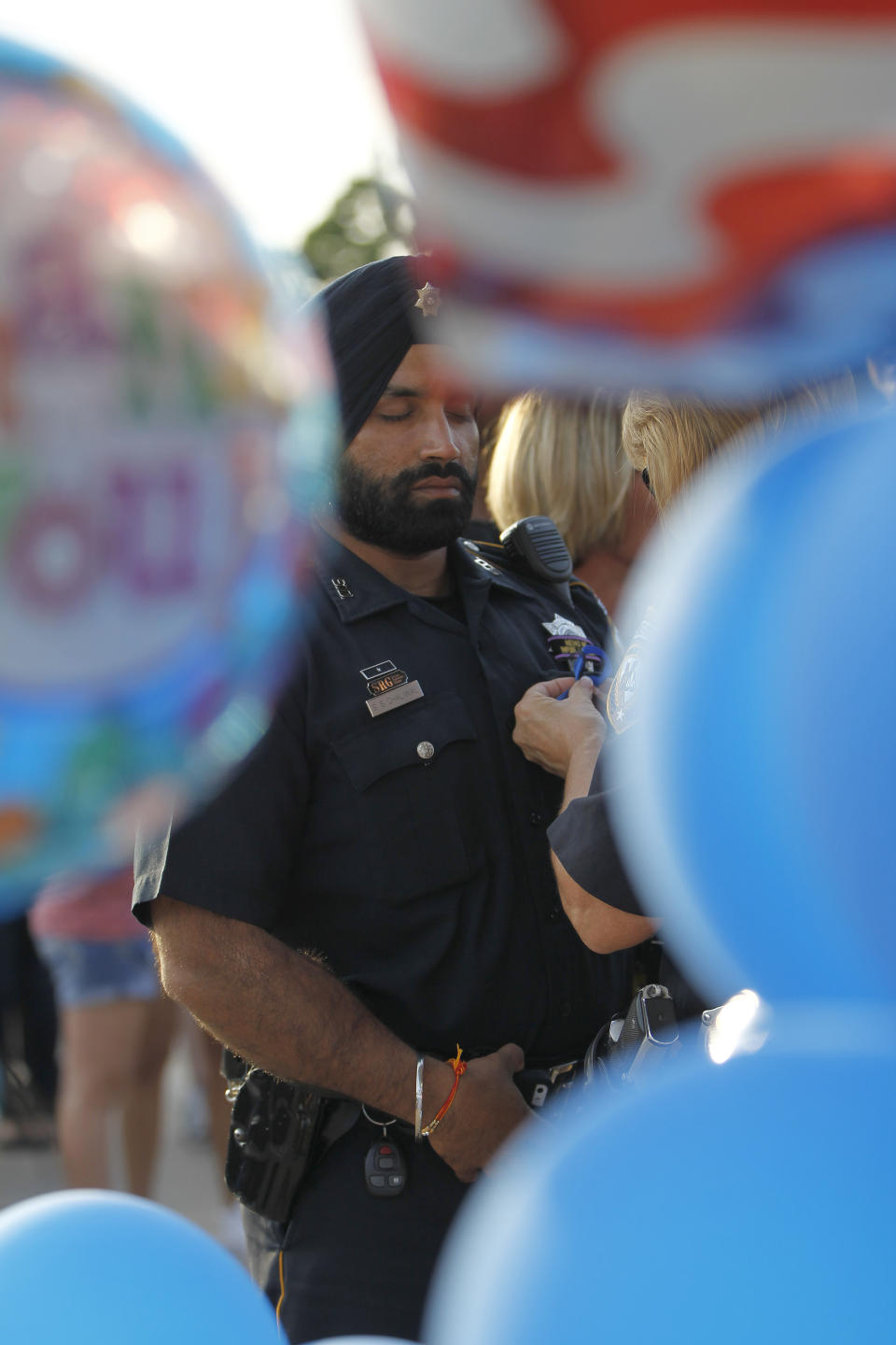 In this Aug. 29, 2015, photo, Harris County Sheriffs deputy Sandeep Dhaliwal gets a blue ribbon pinned to him during a vigil at the Chevron station in Houston, where Harris County deputy Darren Goforth was shot and killed previous night while he was refueling his vehicle. Dhaliwal was shot and killed while making a traffic stop Friday, Sept. 27, 2019, near Houston. (Karen Warren/Houston Chronicle via AP)