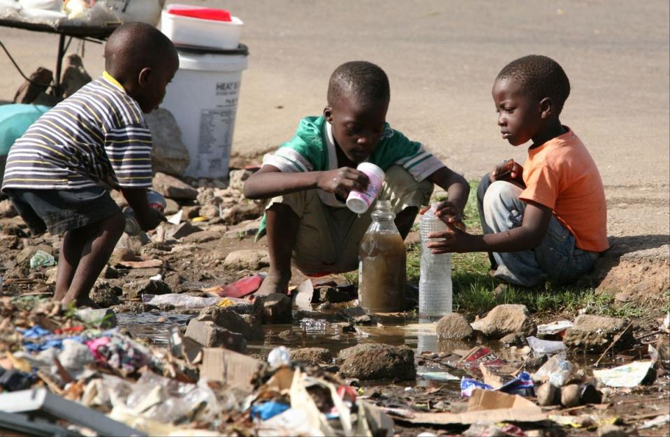 Children collect stagnant water in Glen View, Harare, during the 2008 outbreak (AP)
