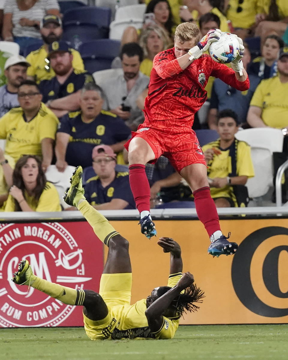 Seattle Sounders goalkeeper Stefan Cleveland makes a save over Nashville SC's C.J. Sapong during the second half of an MLS soccer match Wednesday, July 13, 2022, in Nashville, Tenn. (AP Photo/Mark Humphrey)