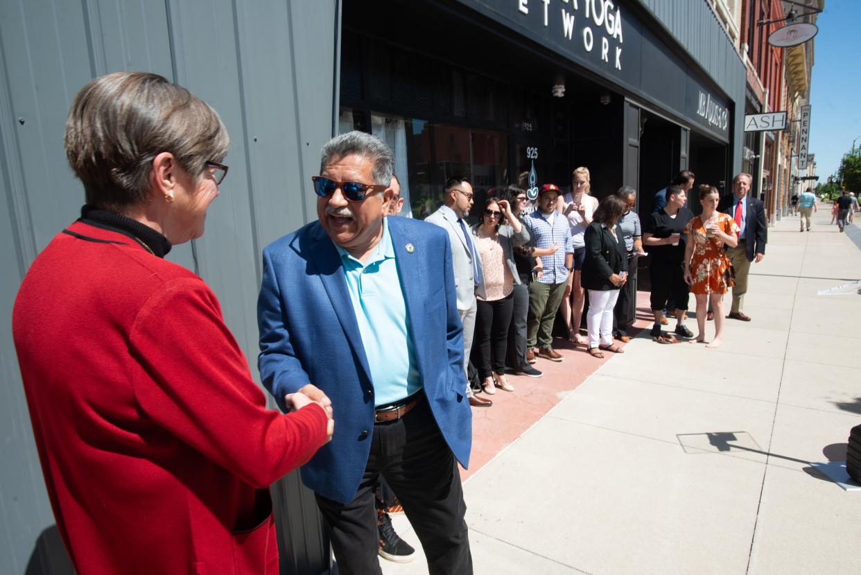 Mayor of Topeka Mike Padilla shakes hands with Gov. Laura Kelly before signing a bill outside of local businesses in downtown Topeka.