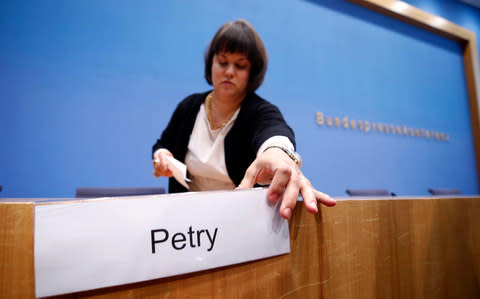 A woman removes sign with the name of Frauke Petry at the end of the Berlin news conference on Monday - Credit: Wolfgang Rattay/Reuters