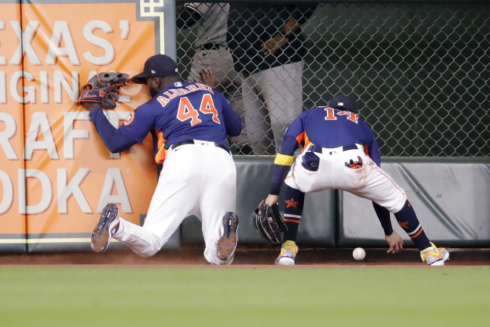 Houston Astros left fielder Yordan Alvarez (44) hits the wall as center fielder Mauricio Dubon (14) tries to get the ball on an RBI double by New York Yankees' DJ LeMahieu during the sixth inning of a baseball game Sunday, Sept. 3, 2023, in Houston. (AP Photo/Michael Wyke)