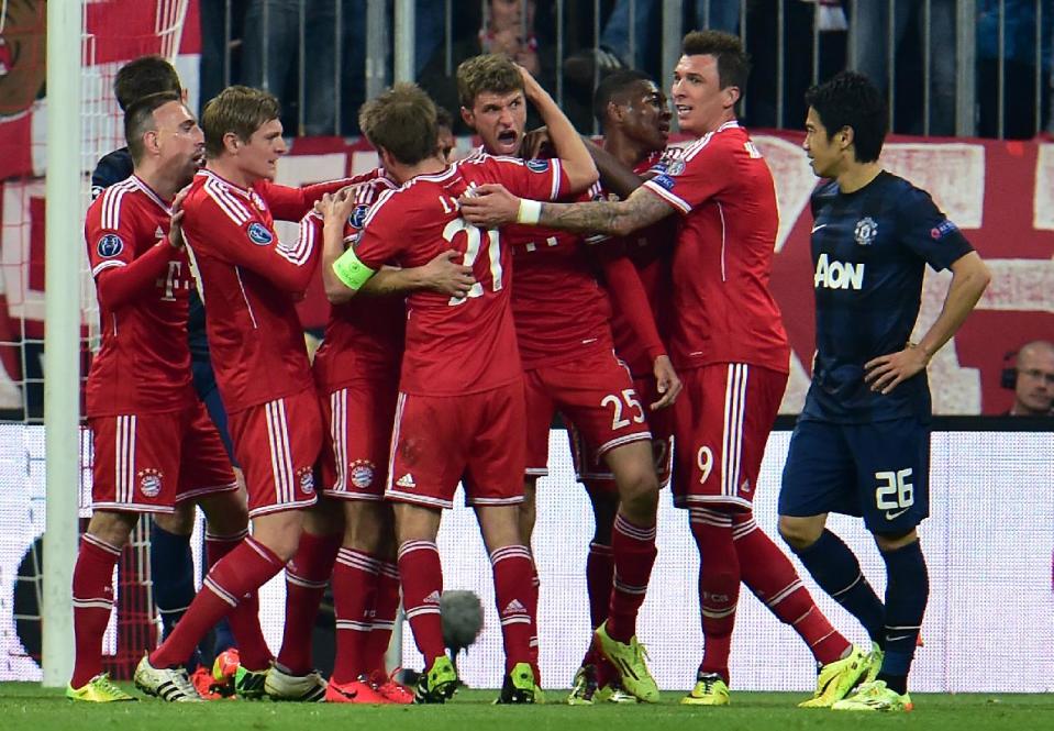 Bayern's scorer Thomas Mueller, center, and his teammates celebrate their side's 2nd goal during the Champions League quarterfinal second leg soccer match between Bayern Munich and Manchester United in the Allianz Arena in Munich, Germany, Wednesday, April 9, 2014. (AP Photo/Kerstin Joensson)
