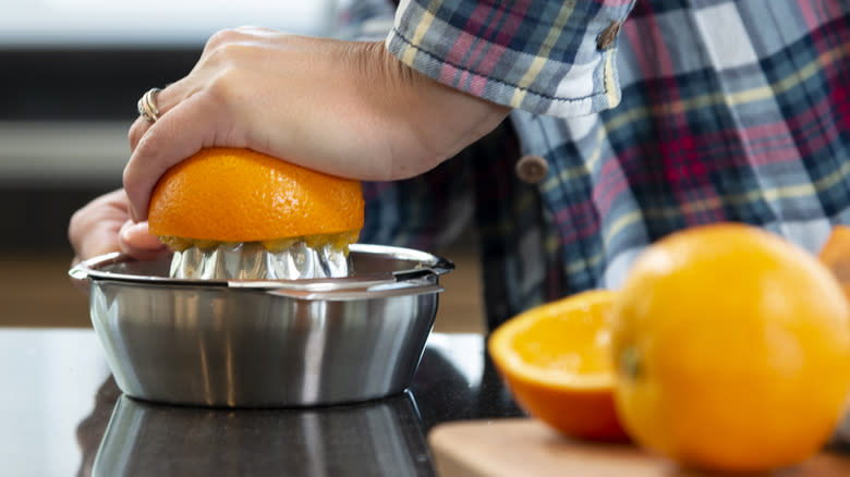 person juicing orange