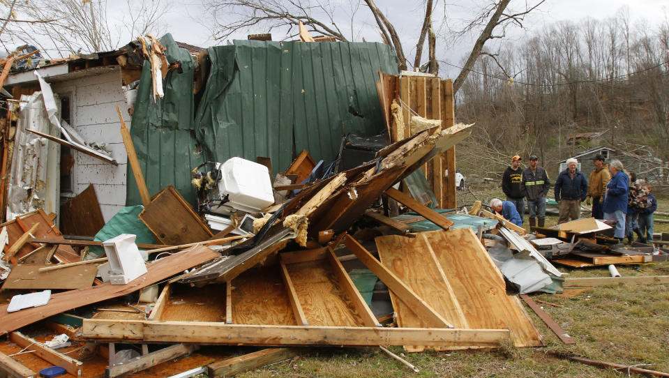 The Shanes family searches through debris of their families home after a tornado ripped through early Wednesday morning Jan. 30,2013, destroying several homes and businesses in Coble, Tenn. (AP Photo/Butch Dill)