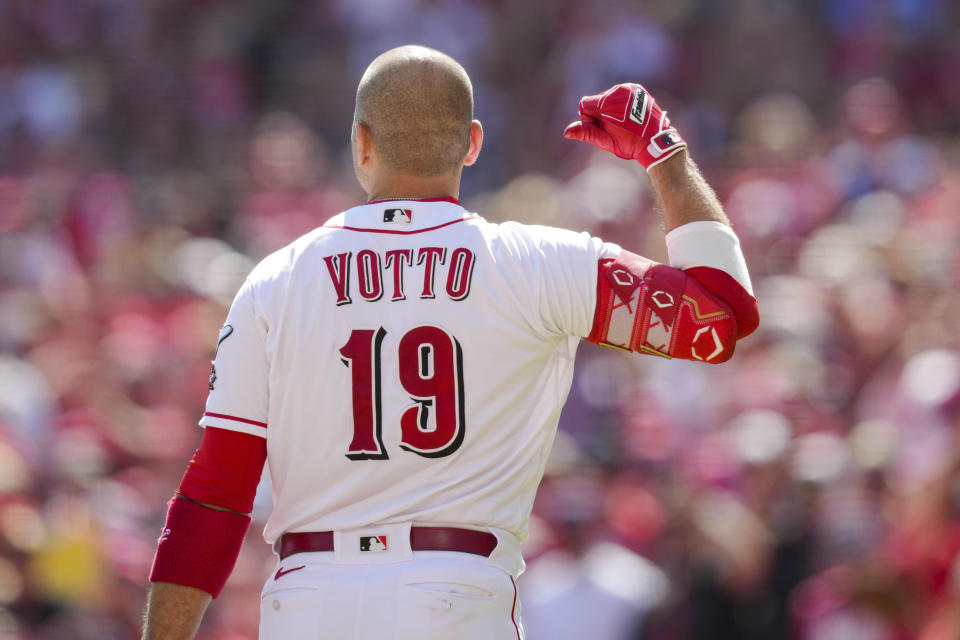 Cincinnati Reds' Joey Votto gestures to his name on his jersey as he acknowledges the crowd while standing at home plate during the second inning of a baseball game against the Pittsburgh Pirates in Cincinnati, Sunday, Sept. 24, 2023. (AP Photo/Aaron Doster)