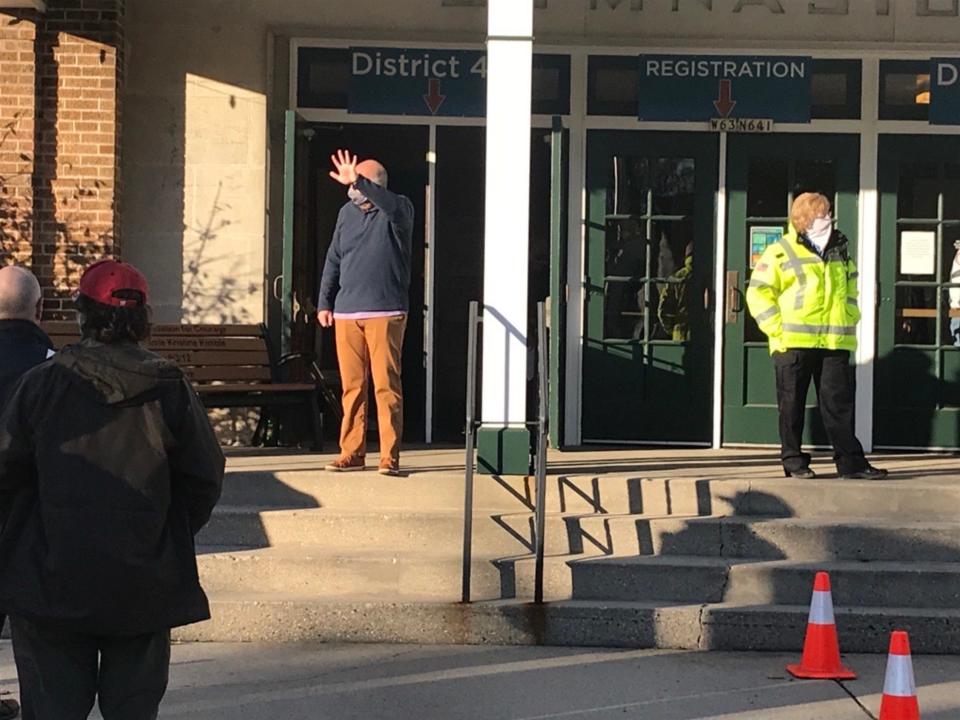 Cedarburg poll workers call out ward numbers to voters waiting in line outside the city's central polling location, the downtown Community Center Gym. A line of about 70 voters, many wearing masks, waited outside during a beautiful fall morning about 7:40 am. Election Day November 3, 2020.