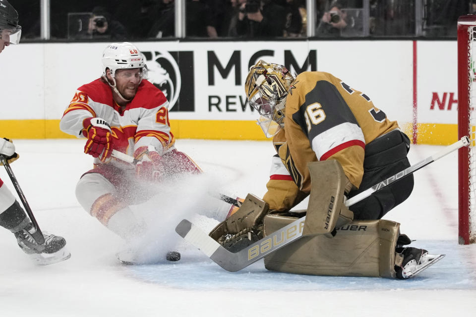 Vegas Golden Knights goaltender Logan Thompson (36) blocks a shot beside Calgary Flames center Blake Coleman (20) during the first period of an NHL hockey game Tuesday, Dec. 12, 2023, in Las Vegas. (AP Photo/John Locher)