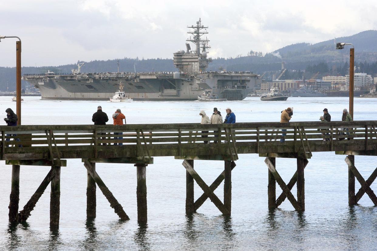 People leave Waterman Dock after watching the USS Ronald Reagan pass by on its way to a year-long overhaul at Puget Sound Naval Shipyard in January 2012. The Reagan will come to Bremerton in 2024 twelve years after the carrier's last visit to the Sinclair Inlet.