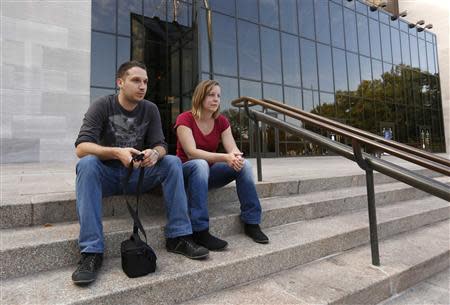 Tourists from France sit on the steps outside the closed Smithsonian Air and Space Museum in Washington October 1, 2013. REUTERS/Kevin Lamarque