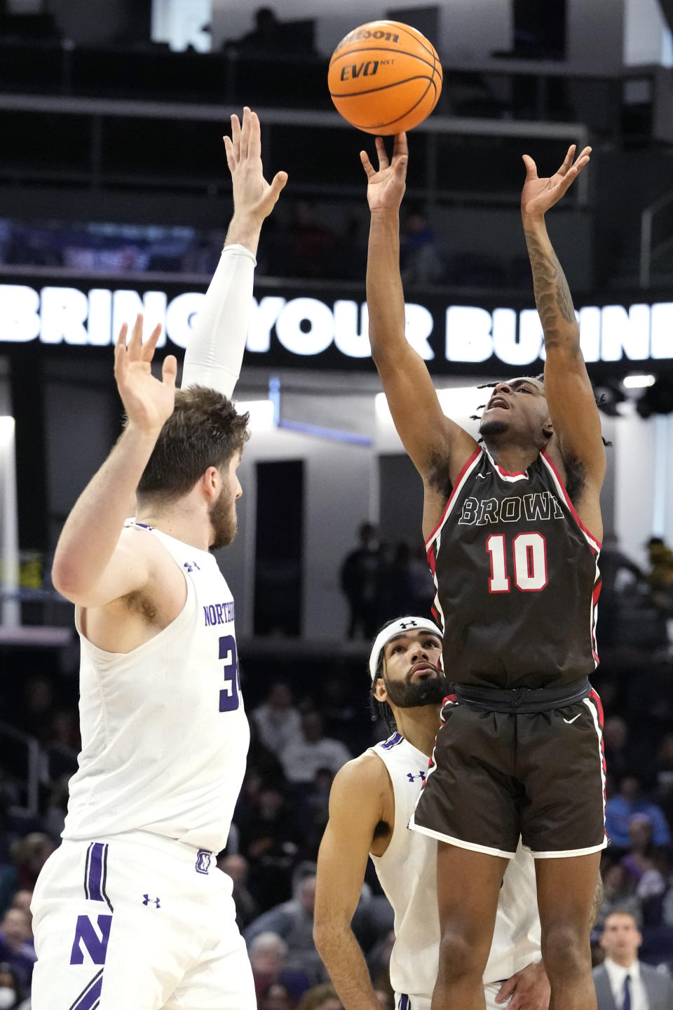 Brown guard Kino Lilly Jr., right, shoots over Northwestern center Matthew Nicholson during the first half of an NCAA college basketball game in Evanston, Ill., Thursday, Dec. 29, 2022. (AP Photo/Nam Y. Huh)