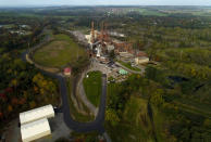 A brief patch of early morning sunlight brightens the landscape around the Greenridge Generation power plant on the banks of Seneca Lake, Friday, Oct. 15, 2021, in Dresden, N.Y. One Bitcoin mining operation in central New York came up with a novel solution in finding cheap energy to run the power-gobbling computer arrays that create and transact cryptocurrency: It took over Greenidge Generation which now produces about 44 megawatts to run 15,300 computer servers, plus additional electricity it sends into the state's power grid. (AP Photo/Julie Jacobson)