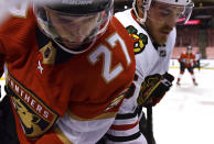 Florida Panthers center Eetu Luostarinen (27) and Chicago Blackhawks right wing Andrew Shaw (65) battle for the puck in the second period of an NHL hockey game Sunday, Jan. 17, 2021, in Sunrise, Fla. (AP Photo/Jim Rassol)