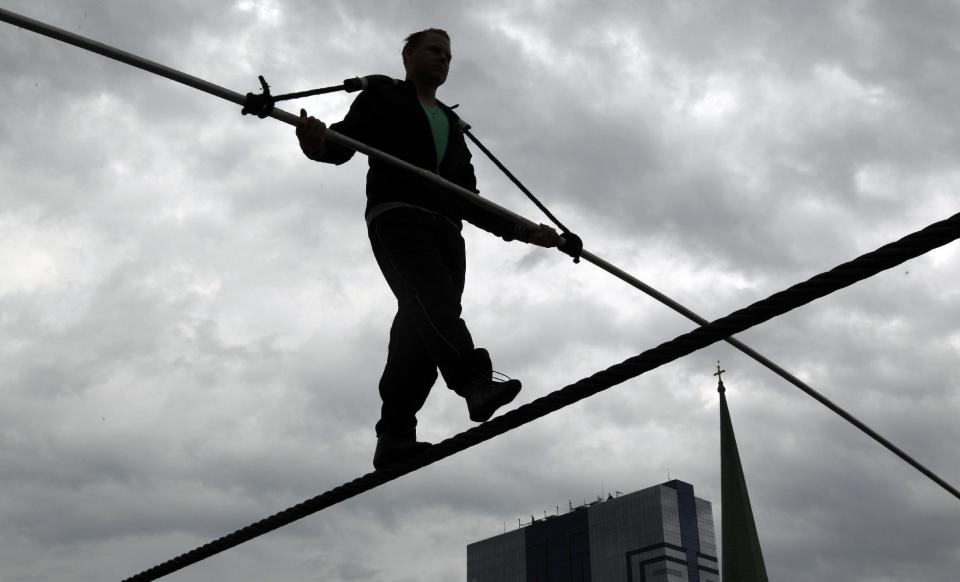 FILE - This May 16, 2012 photo shows Nik Wallenda performing a walk on a tightrope in the rain during training for his walk over Niagara Falls in Niagara Falls, N.Y. Wallenda can't visit a new place without envisioning a wire strung high above his head: Linking buildings, landmarks, nations. Even as a 6-year-old at Niagara Falls with his parents, he pictured walking a tightrope over the raging, whitewater maw. Now 33, he's ready to live out that childhood fantasy when he attempts Friday, June 15, 2012 to become the first person ever to walk a tightrope directly over the brink of Niagara Falls. (AP Photo/David Duprey)