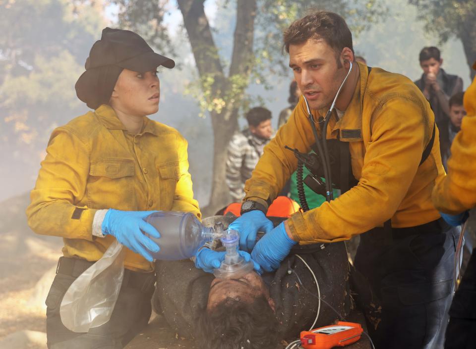 Marjan (Natacha Karam), left, and Eddie (Ryan Guzman) work to save a wildfire victim during Monday's "9-1-1" crossover on Fox's "9-1-1: Lone Star."