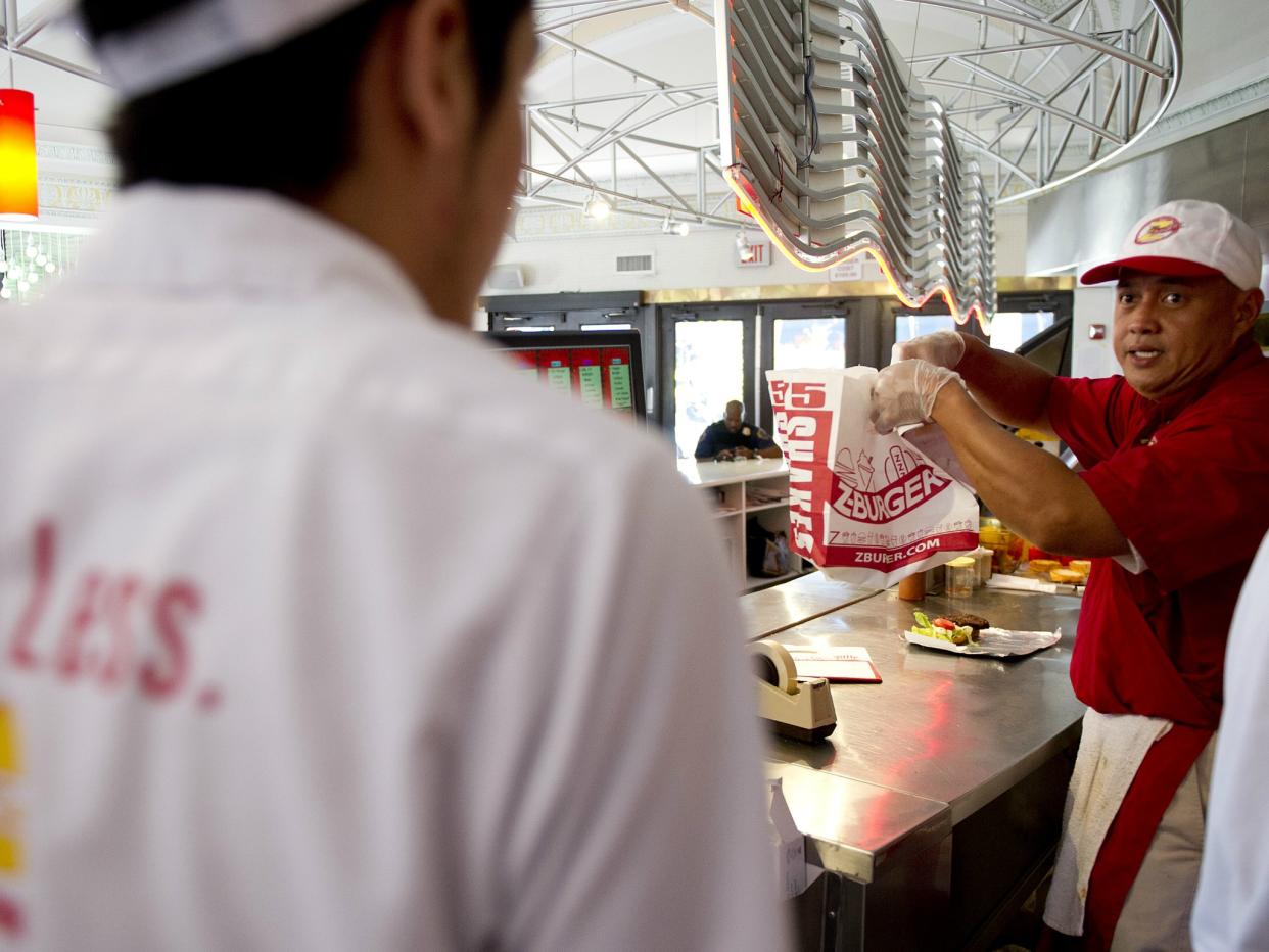 Employees prepare food at a Z-Burger location in the Washington DC area. The chain recently came under fire for using an image of a journalist beheaded by Isis in one of its advertisements: JIM WATSON/AFP/Getty Images
