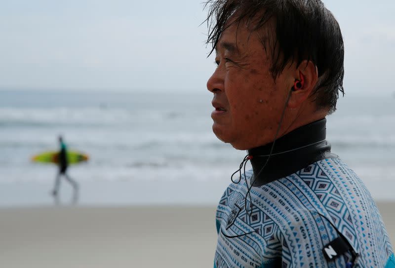 Koji Suzuki, a surfer and a surf shop owner, by the sea in Minamisoma