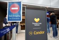 Travellers wait in a Condor check-in service at the Duesseldorf Airport